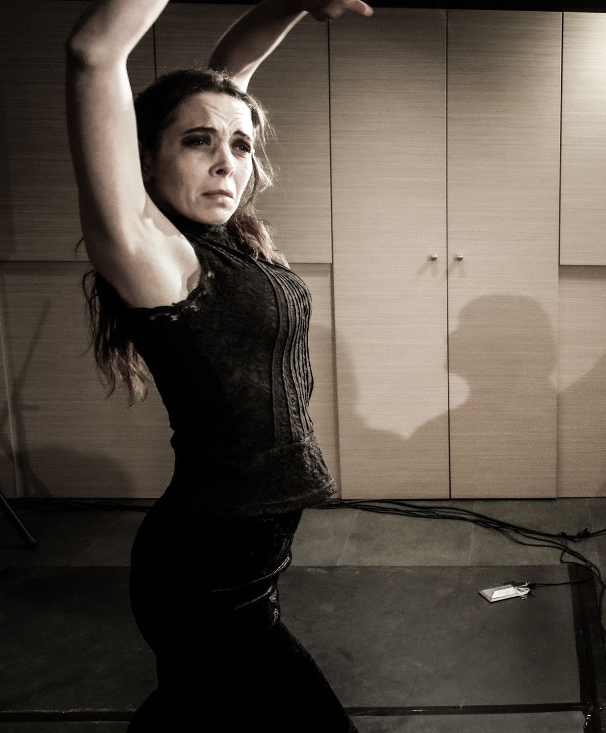 The dancer of the Herencia tablao, arms raised, mid baile flamenco