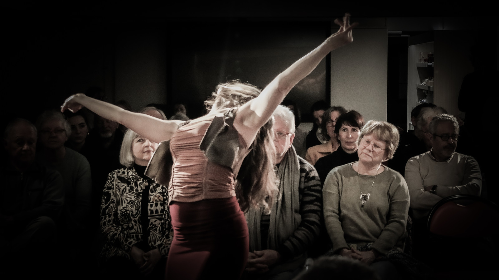 The dancer of the Herencia tablao, arm raised, dancing among the seated audience